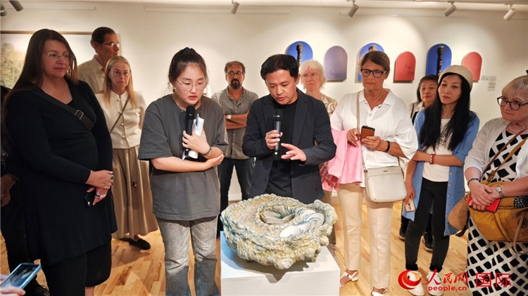 參展人、景德鎮(zhèn)陶瓷大學設計藝術學院副院長余劍峰（中）向來賓介紹參展作品。人民網(wǎng)記者 殷淼攝