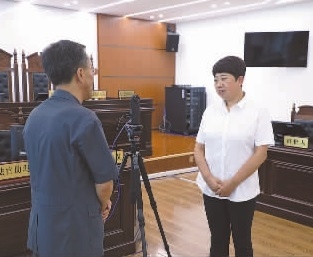 圖為全國人大代表玉明姬（右）詳細(xì)了解環(huán)境資源審判工作情況。劉思妤 攝