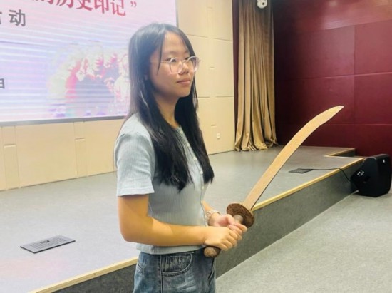 圖為南開(kāi)大學(xué)社會(huì)實(shí)踐隊(duì)學(xué)生代表呼月紅在學(xué)術(shù)交流活動(dòng)現(xiàn)場(chǎng)，展示河間調(diào)研行中獲贈(zèng)的一戰(zhàn)華工蔡世春曾使用過(guò)的一把大刀。林卓瑋 攝
