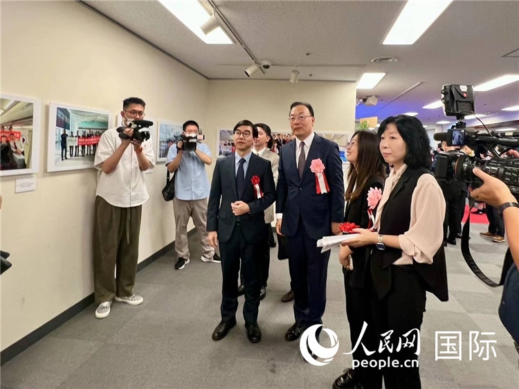 中國國際航空日韓地區(qū)支社支社長馮力為中國駐日本大使館臨時代辦施泳等嘉賓介紹展出圖片。人民網(wǎng) 許可攝
