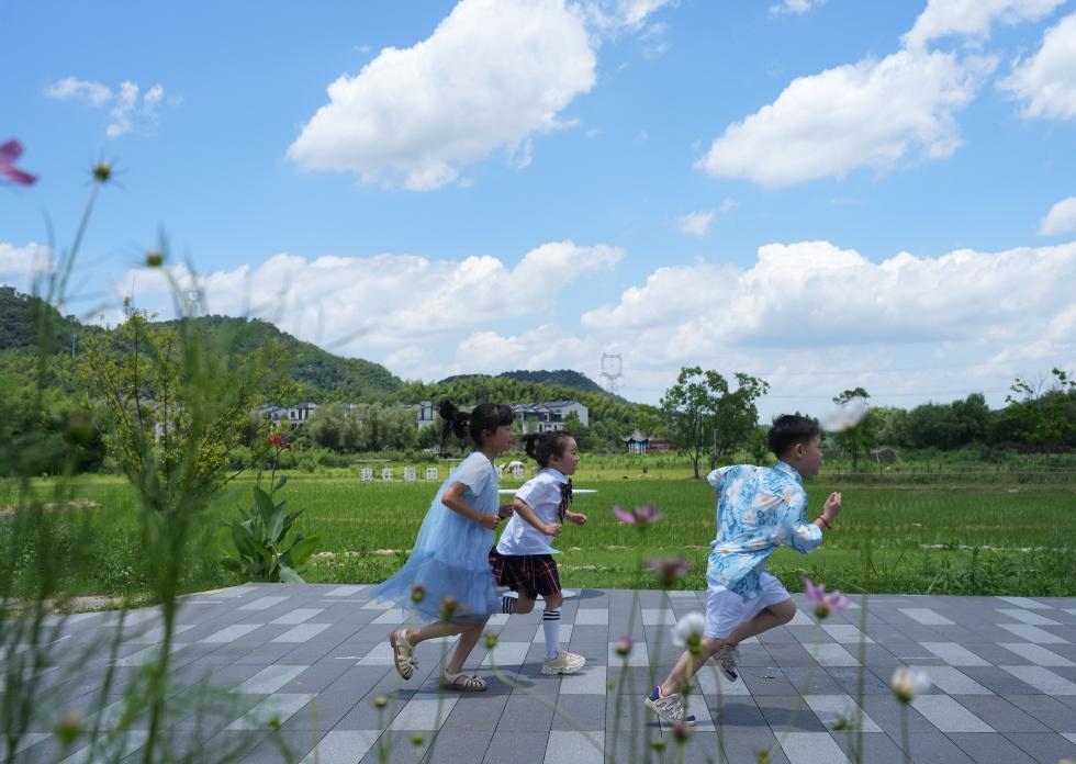 兒童在余姚市梁弄鎮(zhèn)的田野間奔跑（7月3日攝）。新華社記者翁忻旸 攝