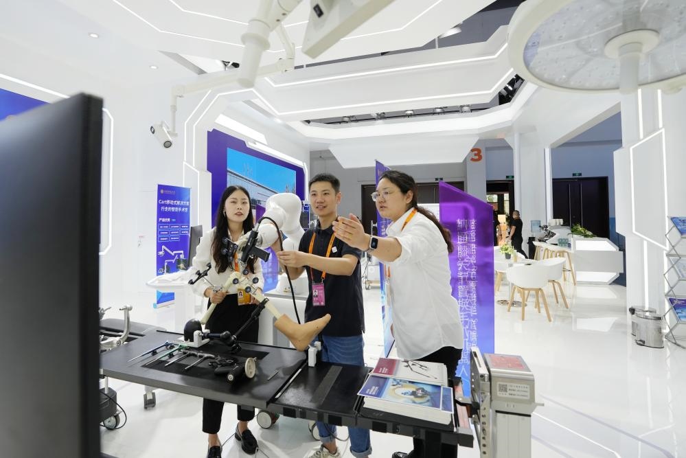 9月11日，一位媒體記者（中）在2024年服貿(mào)會(huì)國家會(huì)議中心會(huì)場(chǎng)體驗(yàn)北京納通科技集團(tuán)有限公司的膝關(guān)節(jié)置換手術(shù)機(jī)器人。新華社記者鞠煥宗 攝