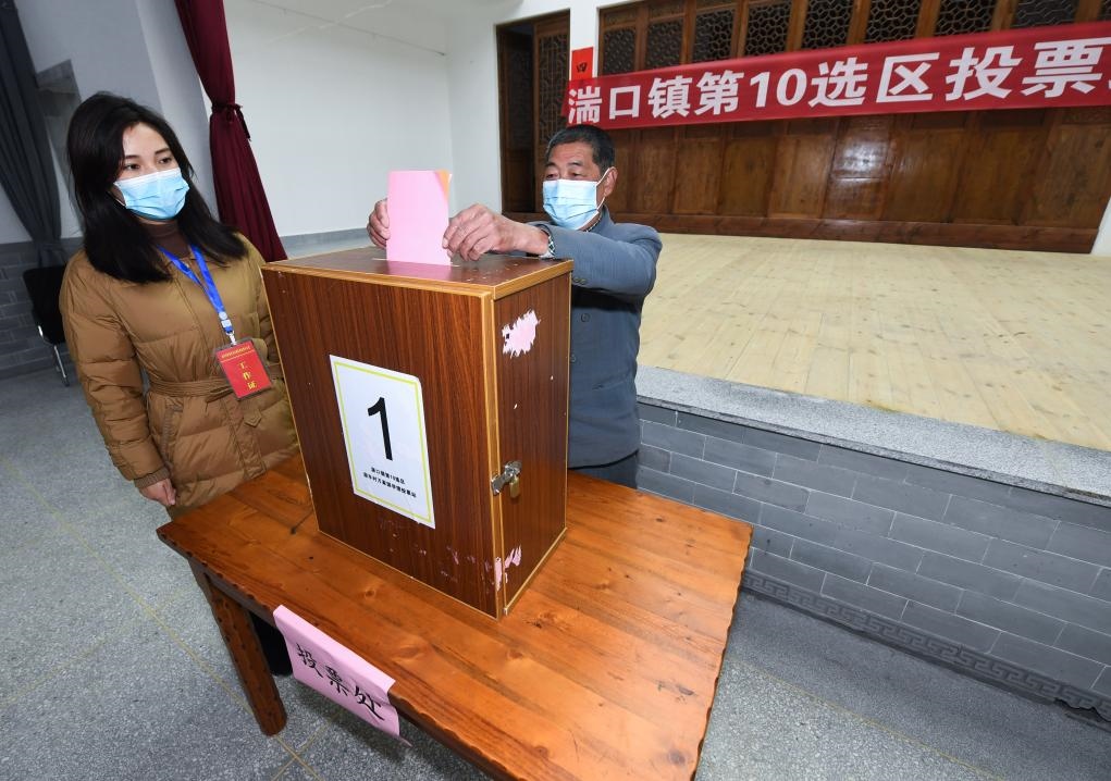 2021年12月14日，在浙江省杭州市臨安區(qū)湍口鎮(zhèn)迎豐村的基層投票點，村民在參加投票，村級監(jiān)察聯(lián)絡員監(jiān)票。新華社記者 徐昱 攝