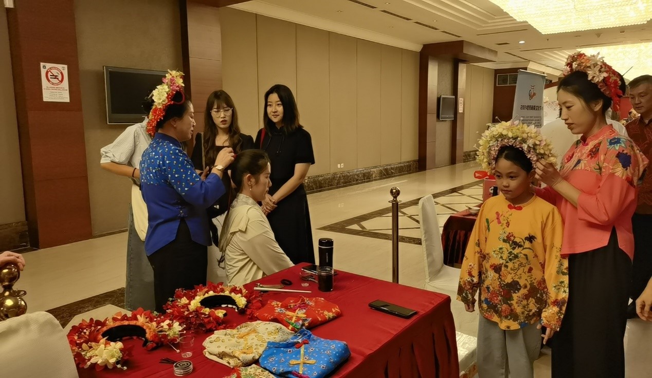 阿拉扎大學(xué)孔子學(xué)院志愿者老師向傳承人學(xué)習(xí)簪花圍。阿拉扎大學(xué)孔子學(xué)院供圖