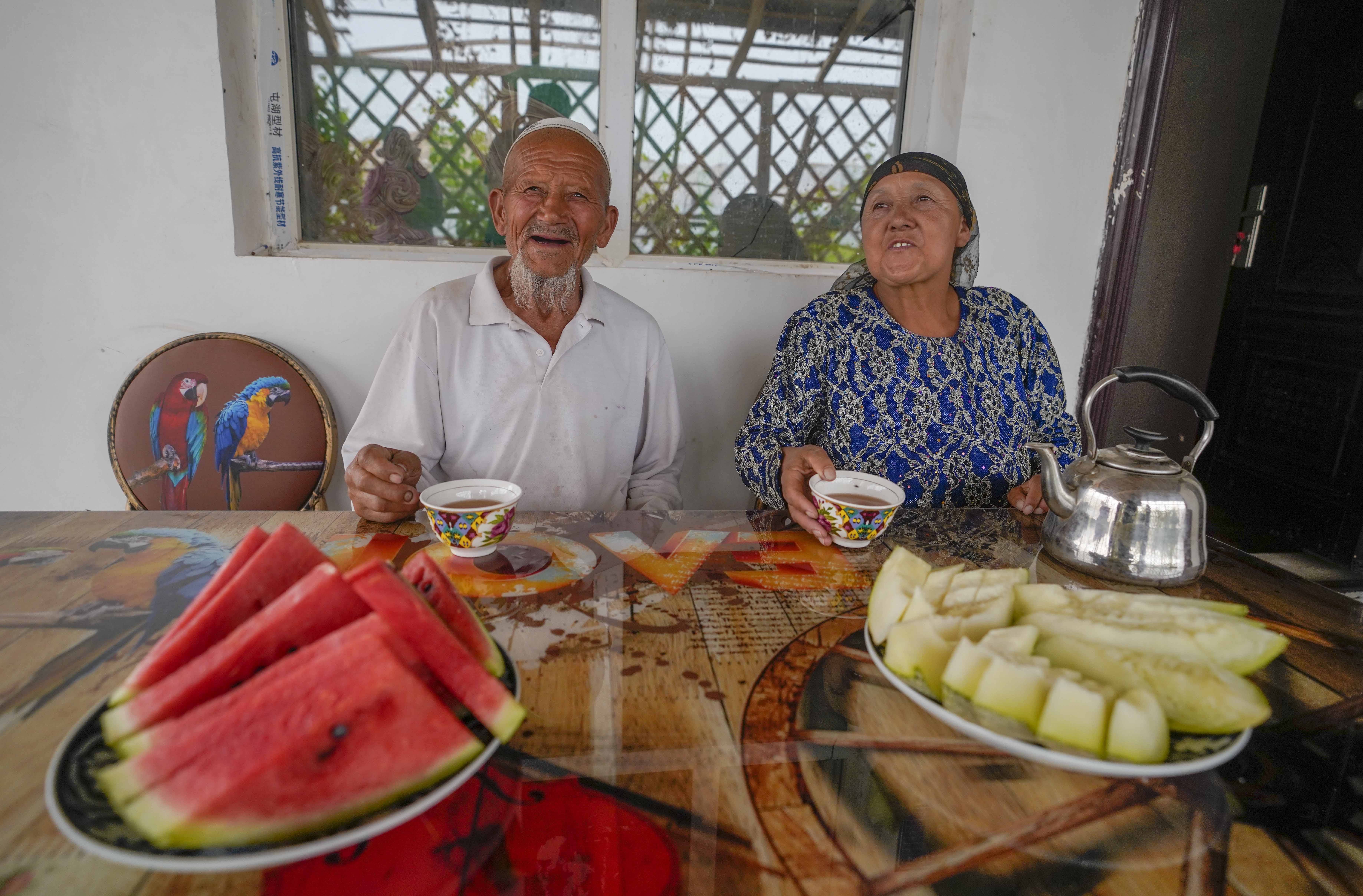 在新疆喀什地區(qū)伽師縣江巴孜鄉(xiāng)依帕克其村57號，80歲的維吾爾族老人伊米提·艾山（左）在自家庭院中（2020年6月8日攝）。