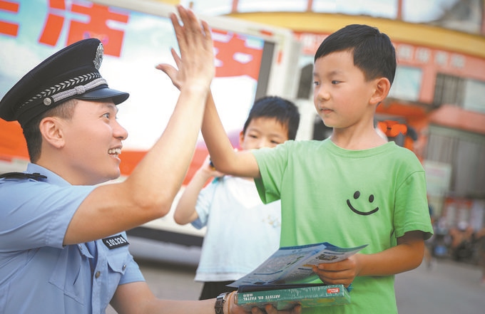 ▲7月10日，江西省吉安市公安局吉州分局組織民警深入轄區(qū)開(kāi)展安全宣傳，民警向小朋友講解防溺水知識(shí)。朱文杰攝