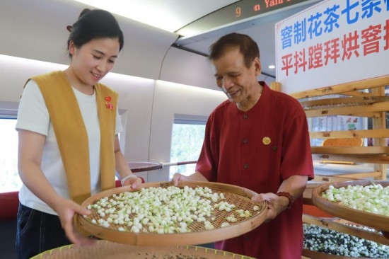 10月1日，福州市茉莉花茶窨制工藝代表性傳承人張子建與旅客在G1634次列車上制作茉莉花茶。新華社記者周義 攝