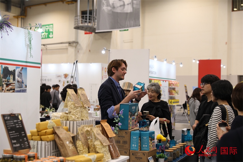 當?shù)貢r間10月5日，在第21屆釜山國際美食博覽會上，意大利展商向參觀者們介紹的意大利食品。人民網(wǎng)記者 莽九晨攝