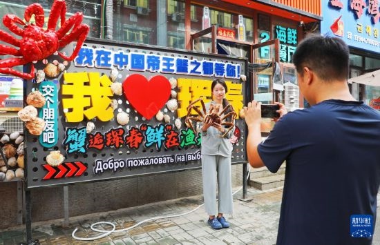 9月21日，游客在吉林省琿春市一處帝王蟹元素主題裝飾前拍照留念。新華社發(fā)