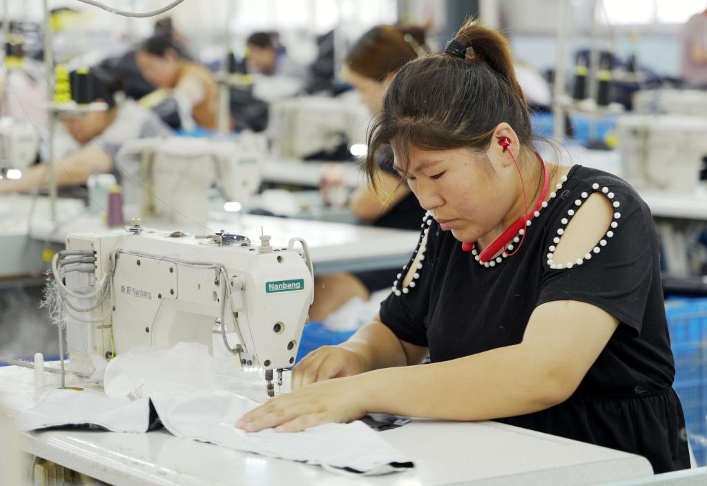 5月20日，村民在李寨村服裝加工廠內(nèi)忙碌。河南省周口市沈丘縣馮營(yíng)鎮(zhèn)李寨村地處豫東平原。近年來(lái)，乘著脫貧攻堅(jiān)與鄉(xiāng)村振興政策的東風(fēng)，李寨村積極探索產(chǎn)業(yè)發(fā)展模式，通過(guò)“龍頭企業(yè)+村集體經(jīng)濟(jì)+農(nóng)戶”的方式，逐漸發(fā)展形成肉牛養(yǎng)殖、設(shè)施農(nóng)業(yè)、服裝加工、康養(yǎng)民宿等產(chǎn)業(yè)，以產(chǎn)業(yè)振興助力鄉(xiāng)村振興。新華社記者 李嘉南 攝
