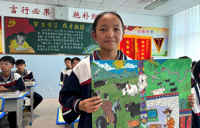 果洛西寧民族中學學生尼東拉毛在主題思政課上展示表現現代化家鄉(xiāng)的作品。