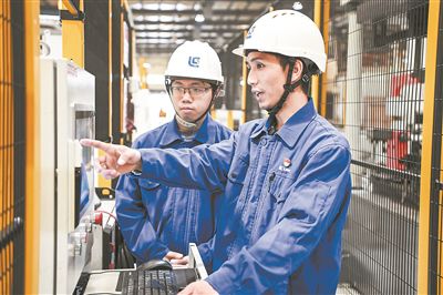 在廣西柳工機(jī)械股份有限公司生產(chǎn)車間內(nèi)，一名高級(jí)技師（右）給徒弟講解數(shù)控設(shè)備操作細(xì)節(jié)。新華社記者 曹祎銘攝