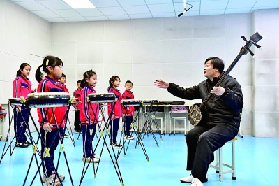 圖為12月30日，在惠民縣胡集鎮(zhèn)第一小學(xué)，老師指導(dǎo)學(xué)生學(xué)習(xí)西河大鼓。新華社記者 郭緒雷攝