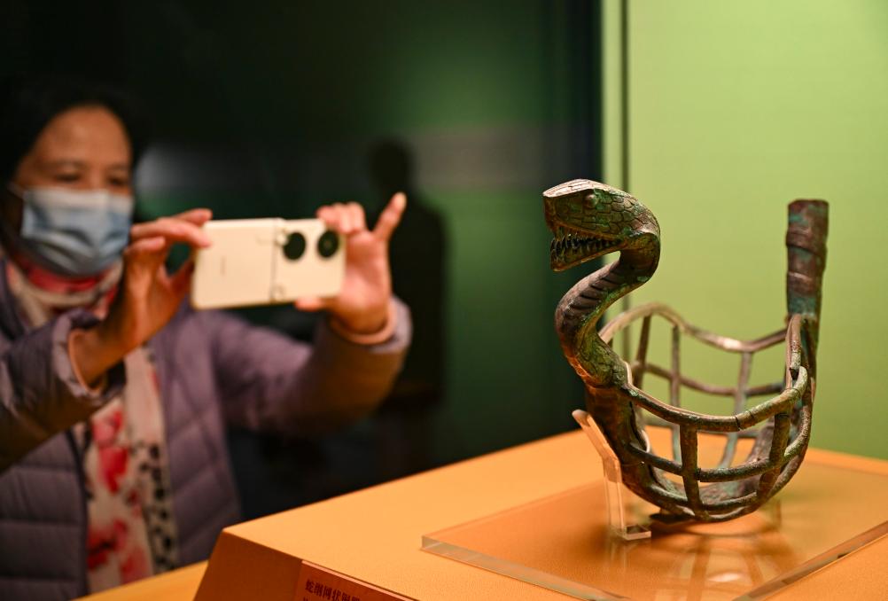 1月14日，觀眾在上海博物館蛇年迎春展拍攝展品蛇綱網(wǎng)狀銅器。新華社發(fā)（陳浩明攝）