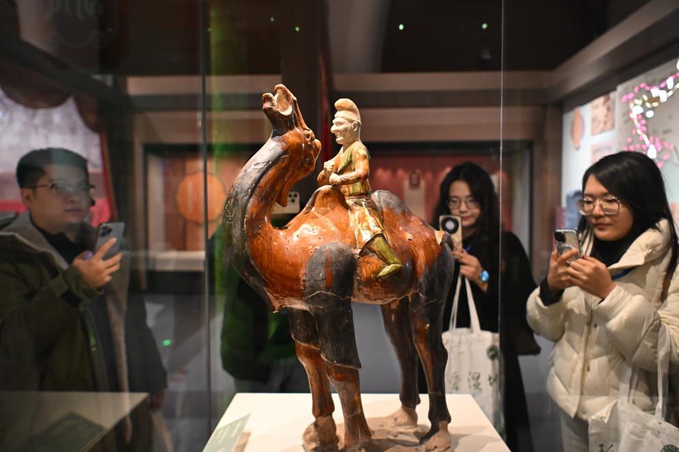 1月15日，觀眾在拍攝“長安三萬里——陜西唐代文物精華展”展出的三彩胡人騎駝俑。（新華社記者 孫凡越 攝）