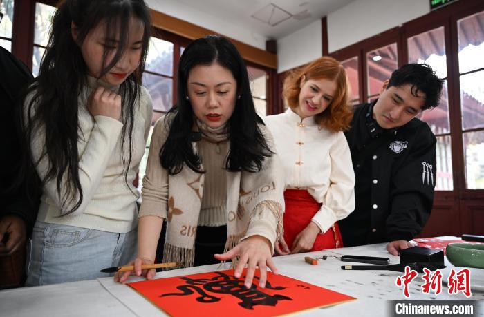 1月20日，西泠印社社員李硯（左二）為外籍留學生講述蛇年福字貼創(chuàng)作靈感。當日，來自巴西、馬來西亞、加納、哈薩克斯坦的外籍留學生在浙江杭州西泠印社體驗福貼、春聯(lián)和篆刻，感受古老的中國傳統(tǒng)文化。中新社記者 王剛 攝