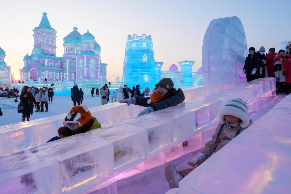 游客在哈爾濱冰雪大世界園區(qū)內(nèi)體驗冰滑梯。新華社發(fā)
