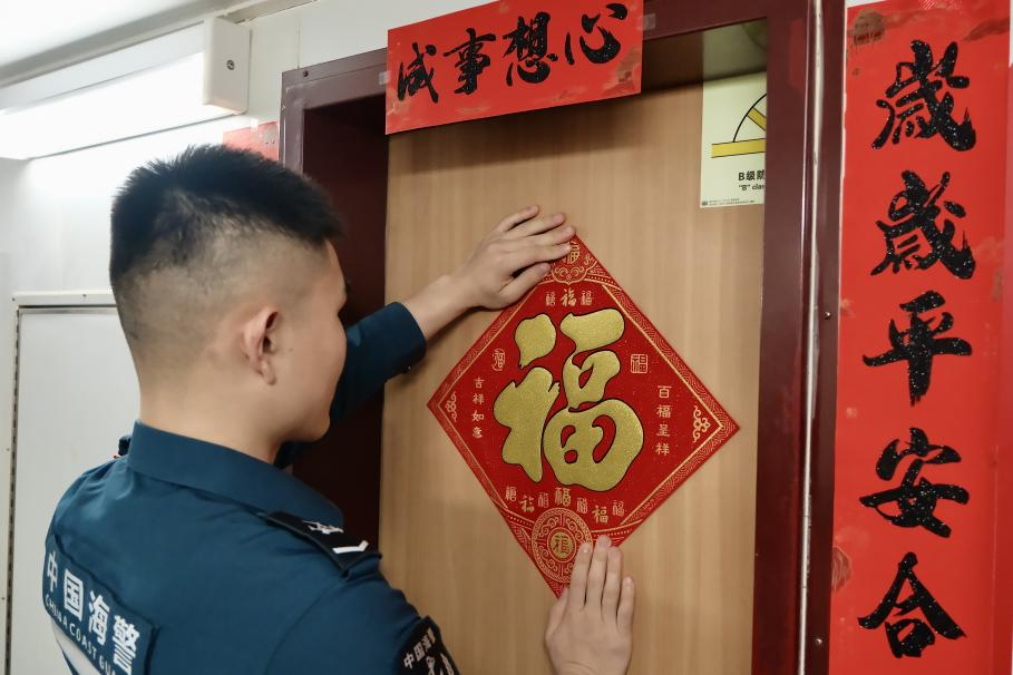 1月27日，在中國(guó)海警海鷗艦上，執(zhí)法員貼春聯(lián)福字慶祝農(nóng)歷春節(jié)。
