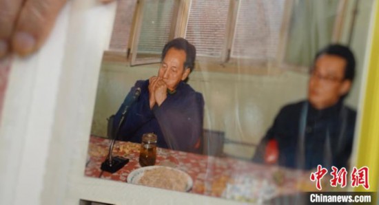 2月7日，劉潤林展示1986年黃旭華(左)在同樂會上吹口琴的老照片。中新社記者 鄒浩 攝