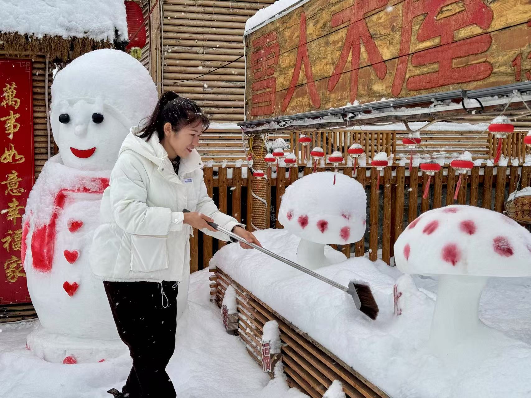史瑞娟在整理民宿院里的冰雪雕塑（央廣網記者馬俊瑋 攝）