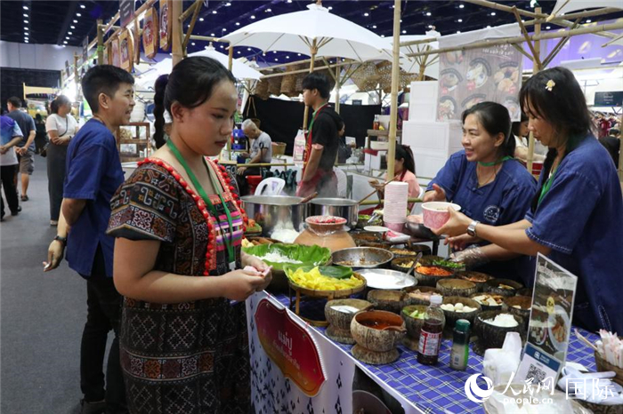游客在攤位前購買特色美食。朱瀟逸攝