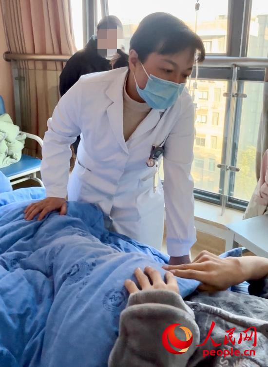 鄧茜查房時詢問患者情況。人民網(wǎng)記者 金慧慧攝