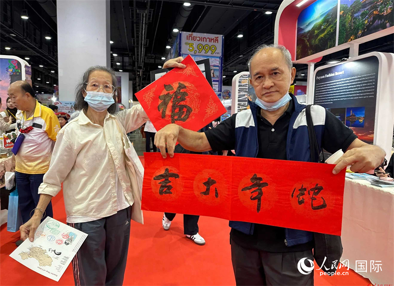 2025蛇年春節(jié)，泰國市民展示他們領(lǐng)到的華人手寫春聯(lián)。人民網(wǎng)記者 簡承淵攝