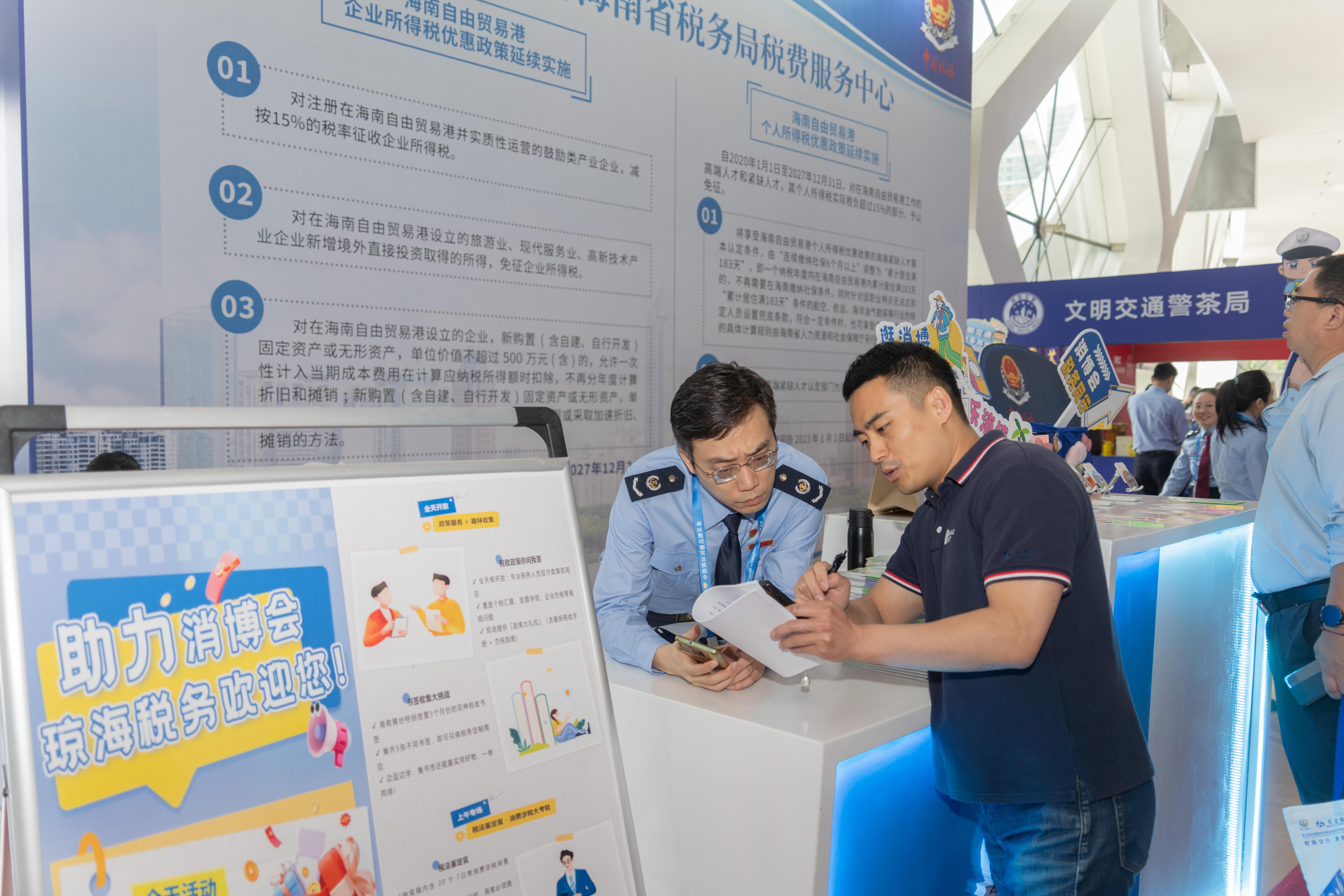稅務服務臺工作人員向記者介紹服務參展外商的具體舉措。人民網(wǎng)記者 許崢攝