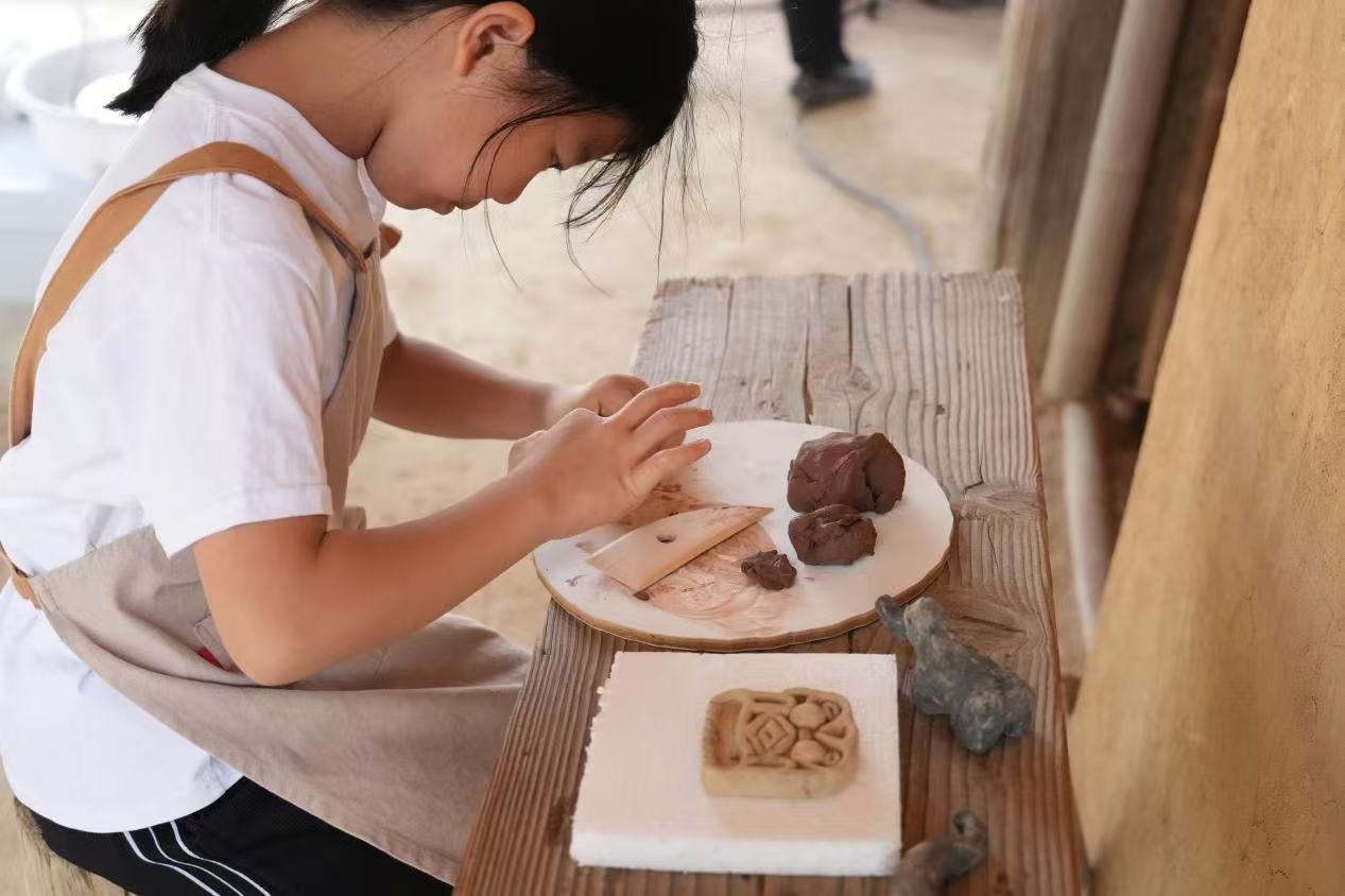 游客制作良渚特色陶藝品。良渚博物院供圖