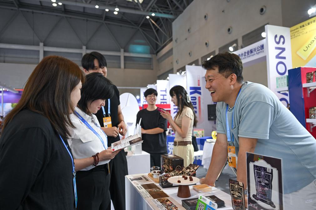 5月22日，韓國展商（右一）在西洽會現(xiàn)場向參觀者介紹產(chǎn)品。新華社記者 陳誠 攝