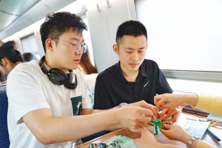 G232次旅客親手制作端午荷包和五彩繩。王磊攝
