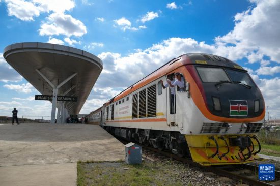 5月31日，在蒙內(nèi)鐵路內(nèi)羅畢站，機(jī)車駕駛員蔣立平（右）和博爾在即將開往蒙巴薩的E2次列車上揮手致意。新華社記者 楊光 攝