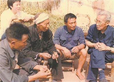侯光炯（右一）和農民在一起親切交流。 西南大學檔案館供圖