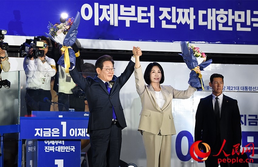 6月4日凌晨，確定當(dāng)選韓國總統(tǒng)的李在明舉手向歡呼的支持者們致意。 人民網(wǎng) 康炯彬攝